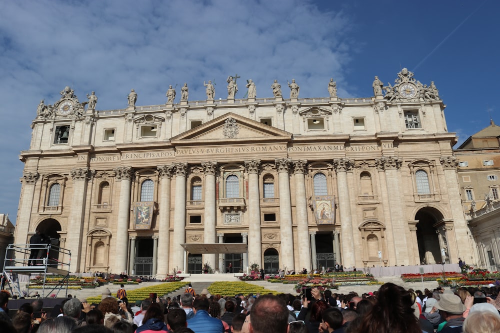 a crowd of people standing in front of a large building