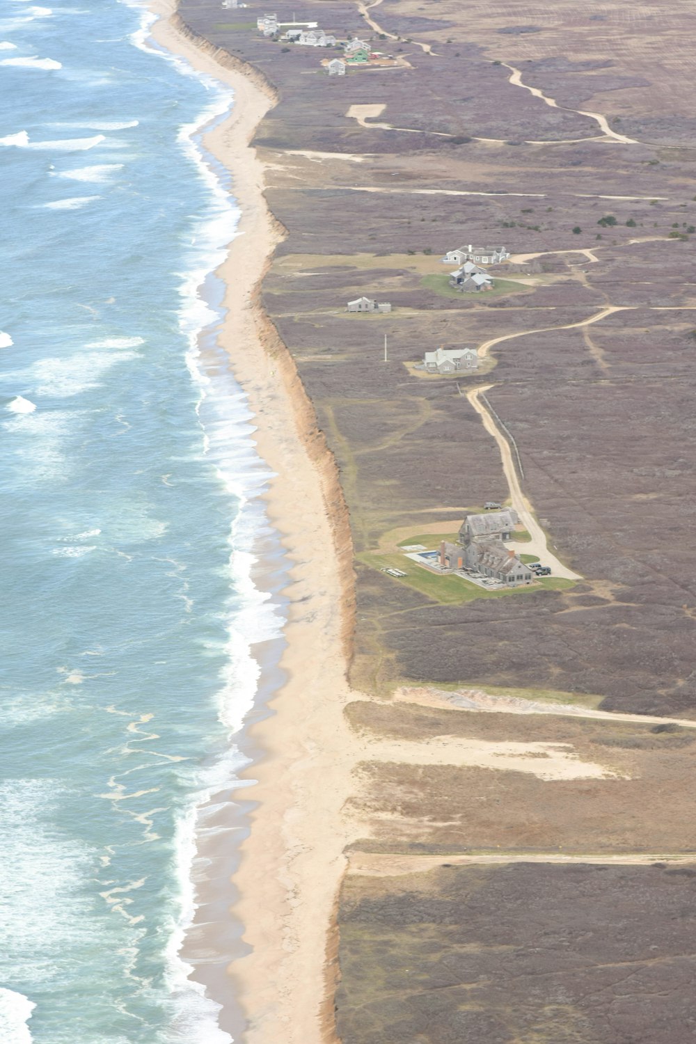 an aerial view of a beach with houses and a body of water