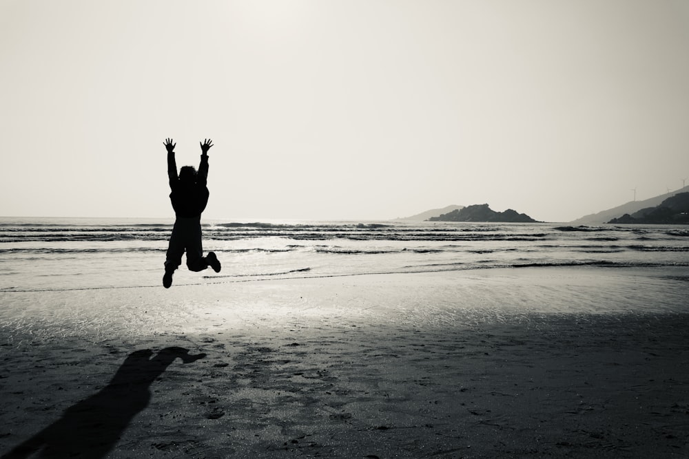 a person jumping in the air on a beach