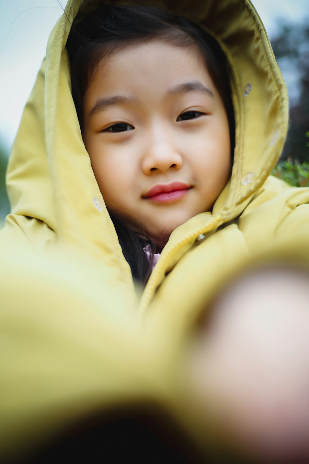 Foto Una niña con una chaqueta amarilla mirando a la cámara – Vestir gratis en Unsplash