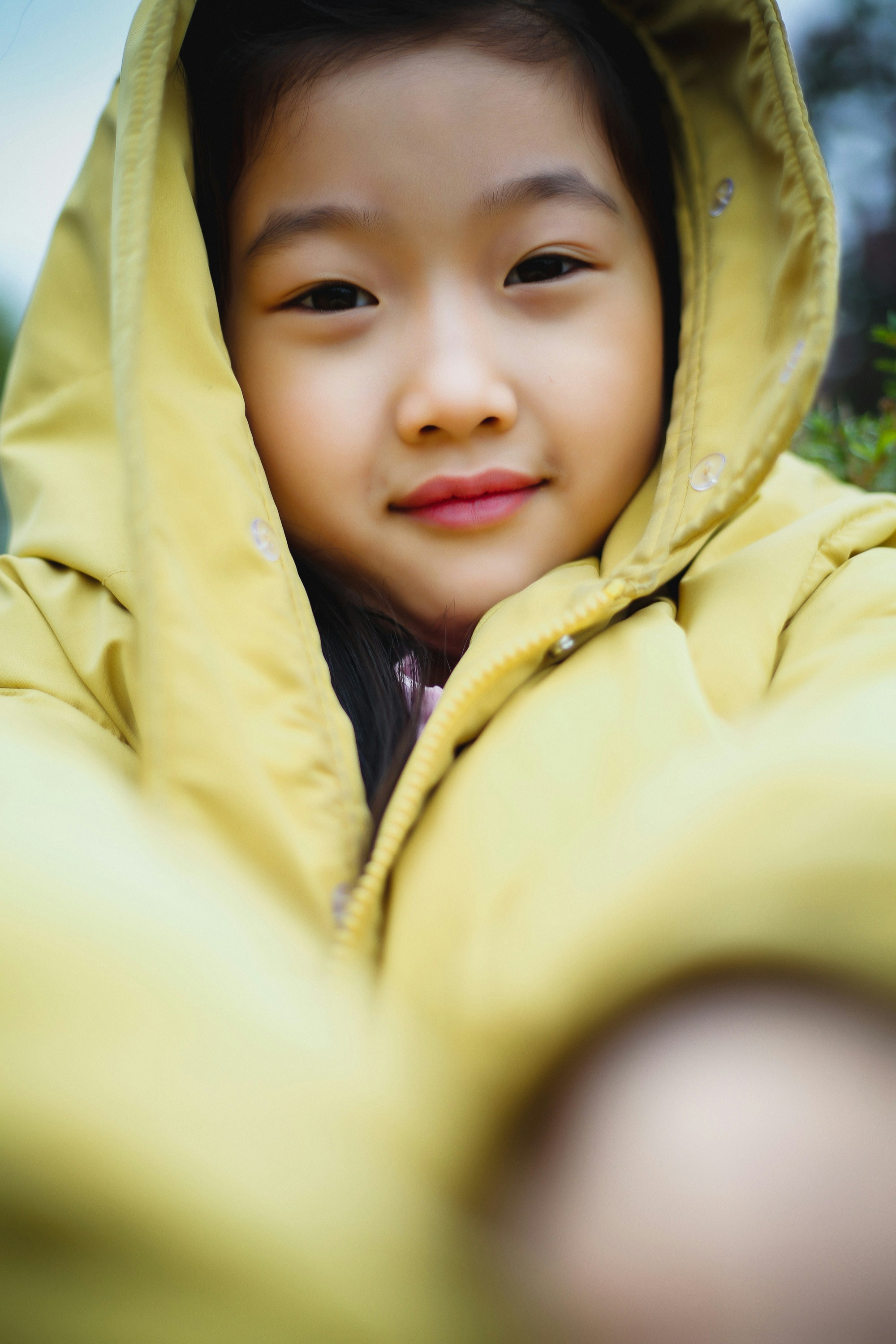 A little girl wearing a yellow jacket and smiling photo Free Clothing Image on Unsplash