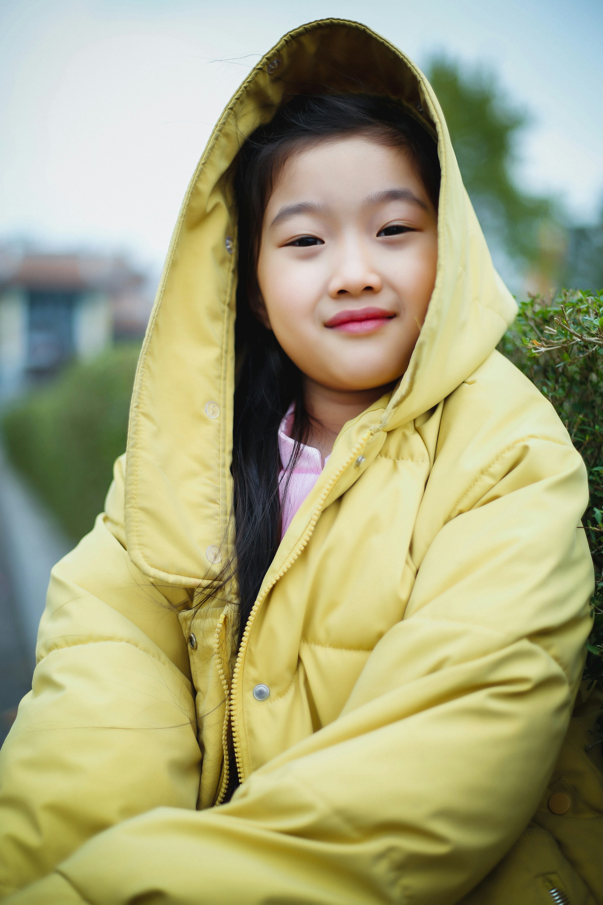A young girl in a yellow coat posing for a picture photo Free