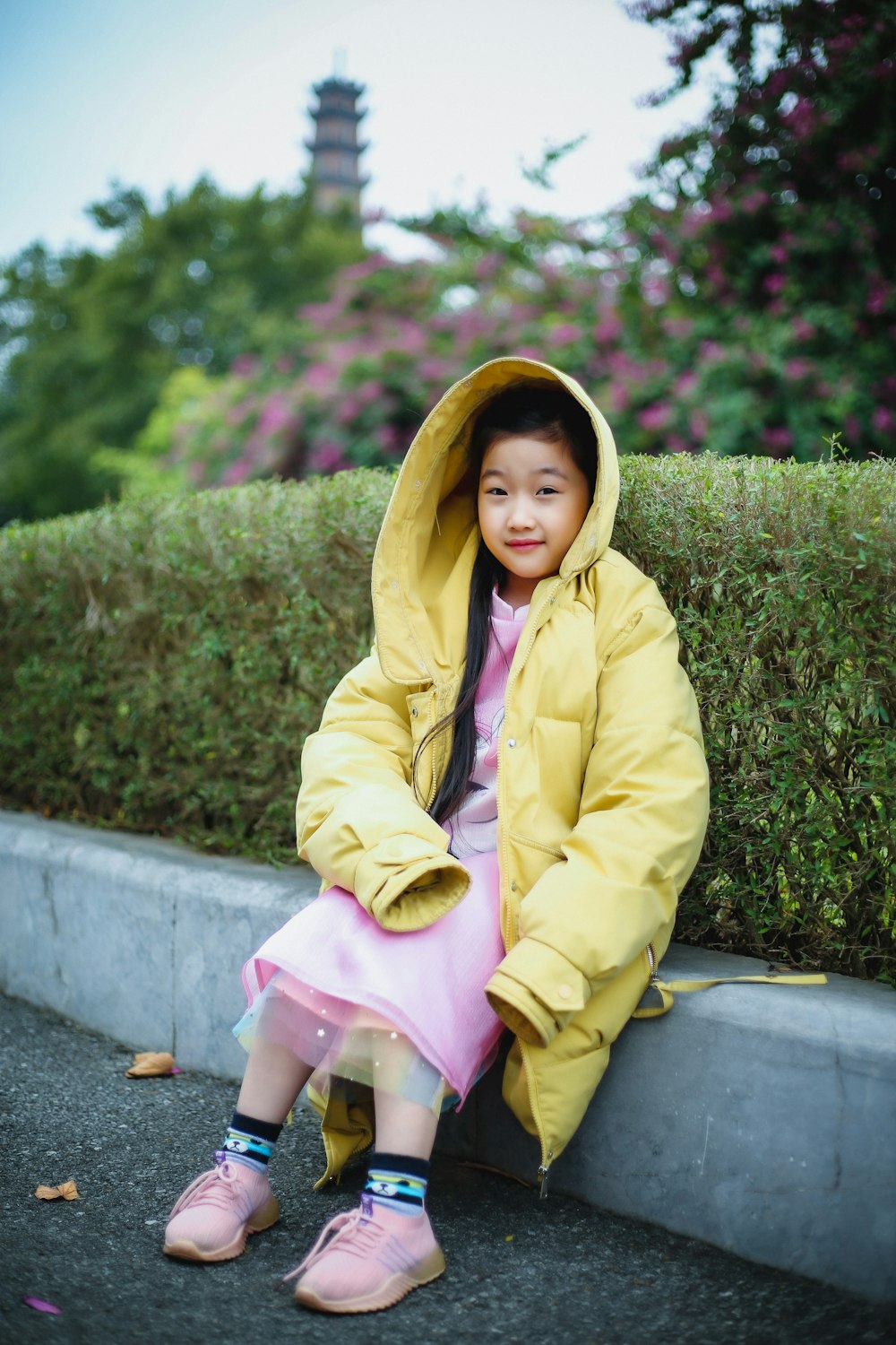 De Verdad tráfico Por nombre Foto Una niña con un abrigo amarillo sentada en una acera – Imagen Vestir  gratis en Unsplash