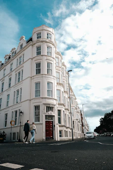 a couple of people walking down a street next to a tall building