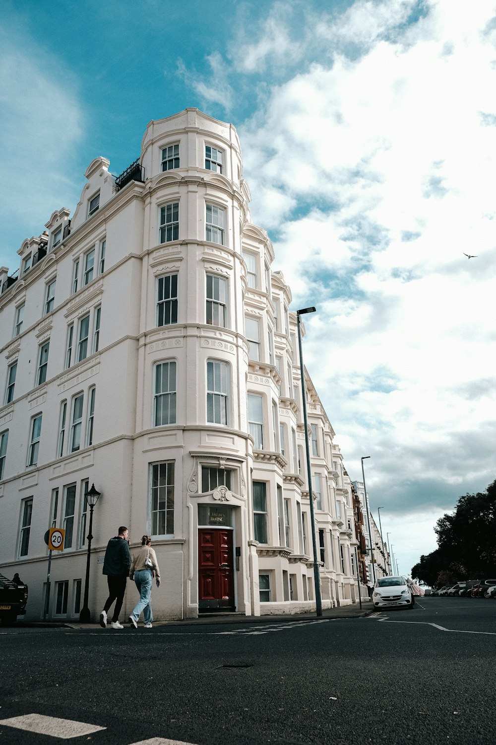 a couple of people walking down a street next to a tall building