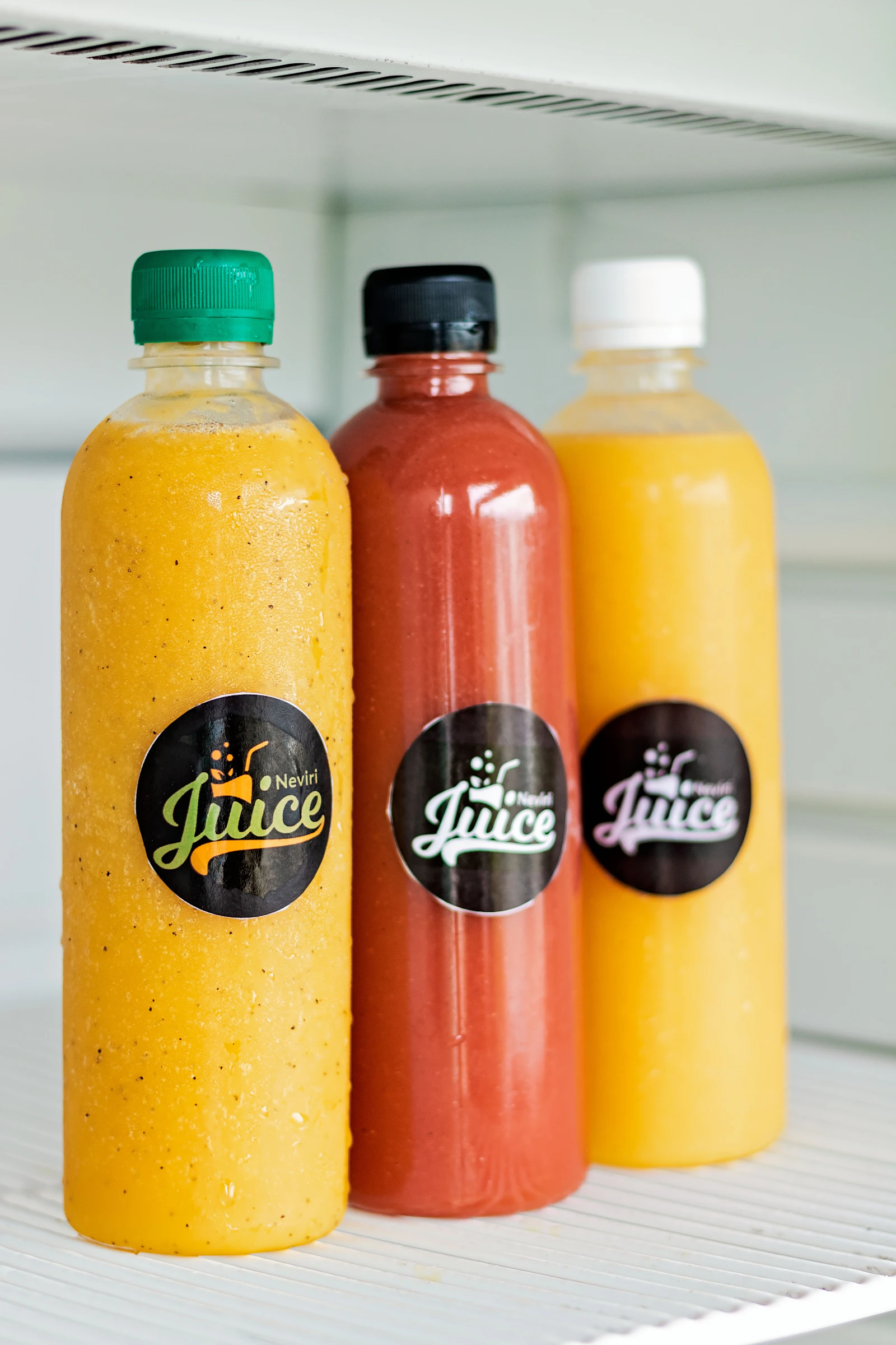 Three bottles of fresh juice on a shelf