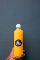 a person holding a bottle of juice in their hand