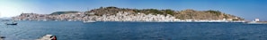 Panoramic view of Melilla’s coastline with fishing boats gently bobbing in the harbor under a clear blue sky