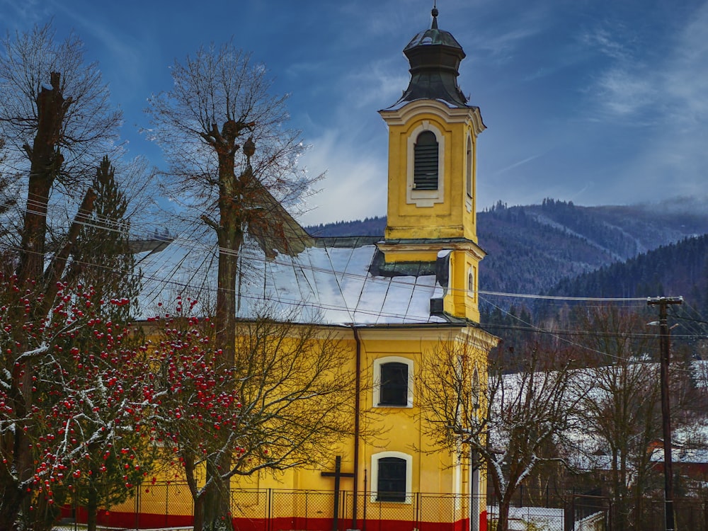 a yellow church with a cross on the top of it