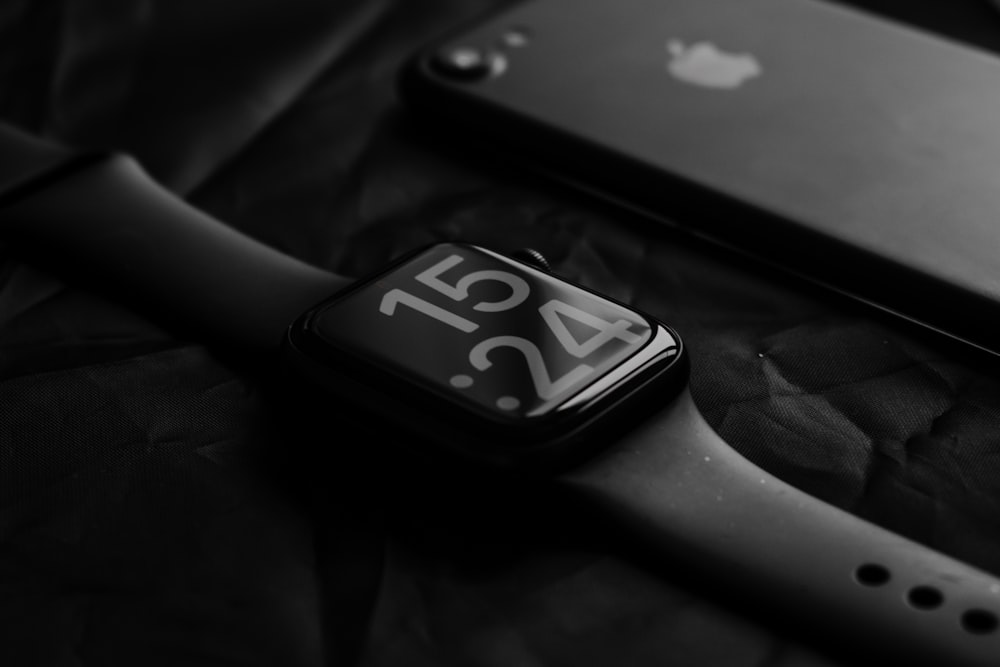 an apple watch sitting on top of a table next to a knife