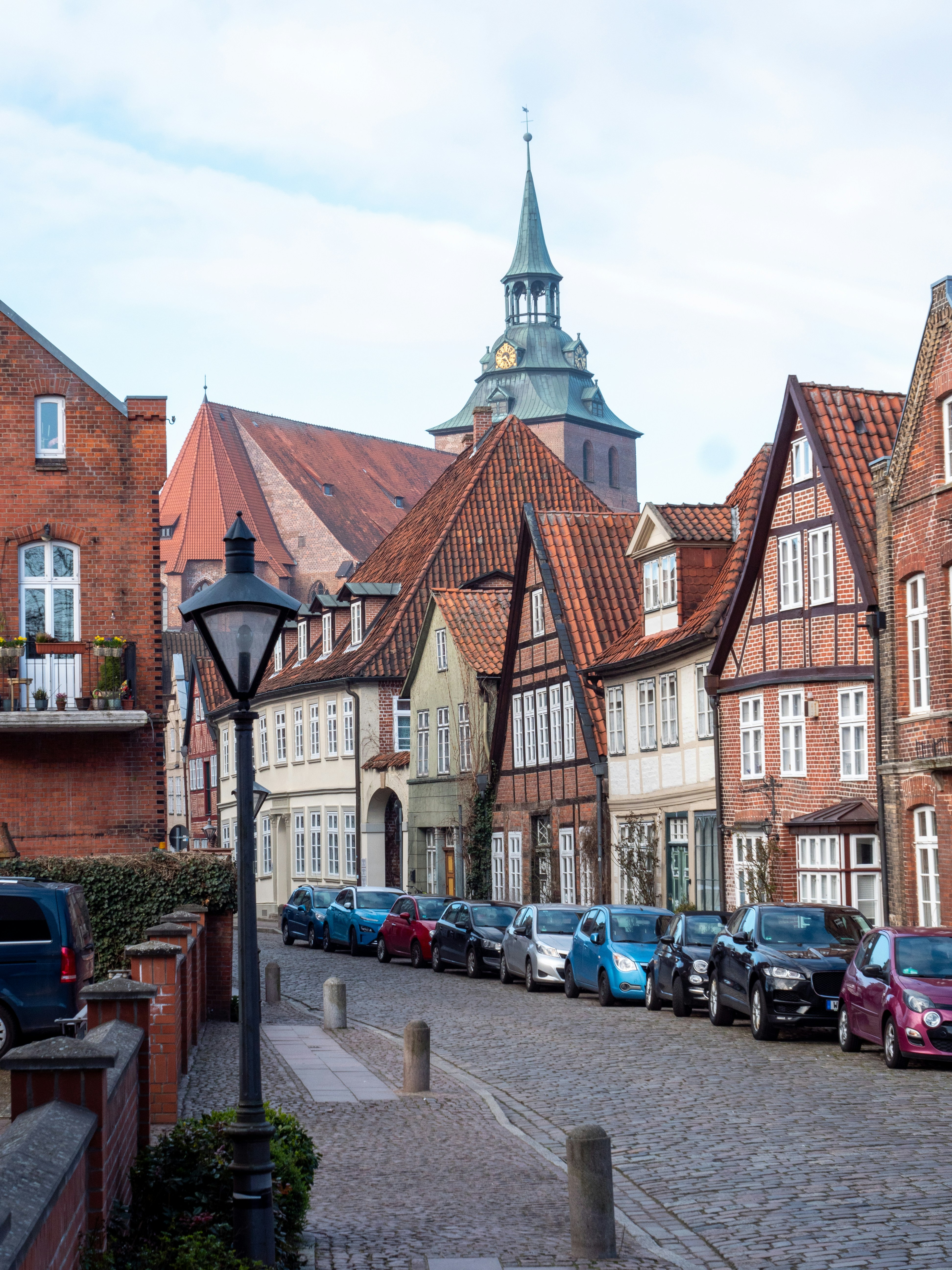 a row of parked cars on a cobblestone street
