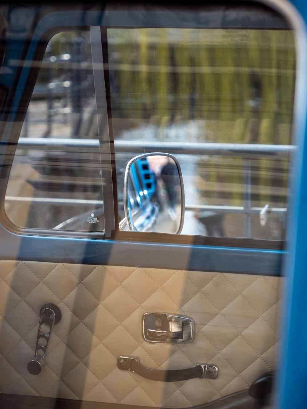 a side view mirror of a car with a reflection of a person in it