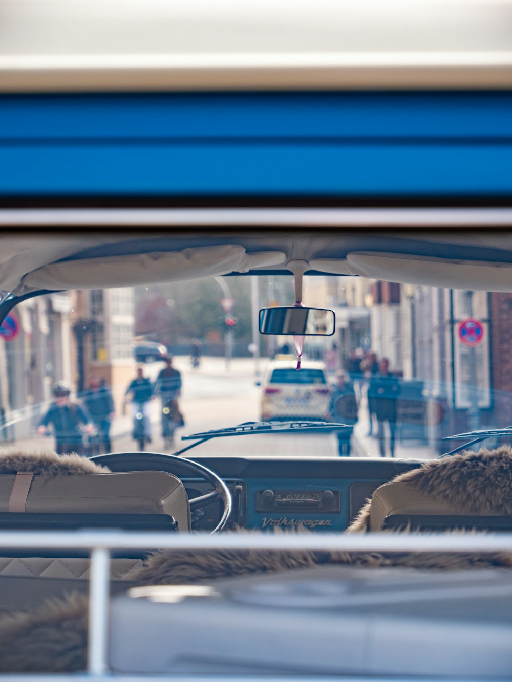 a view from inside a car of people walking on the street
