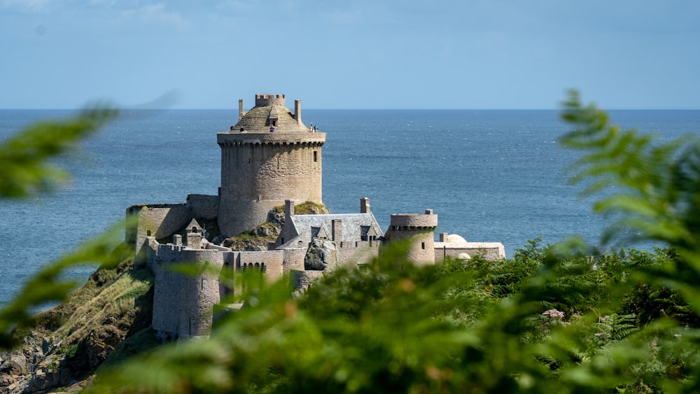 a castle sitting on top of a cliff next to the ocean