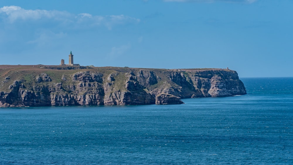 a lighthouse on an island in the middle of the ocean