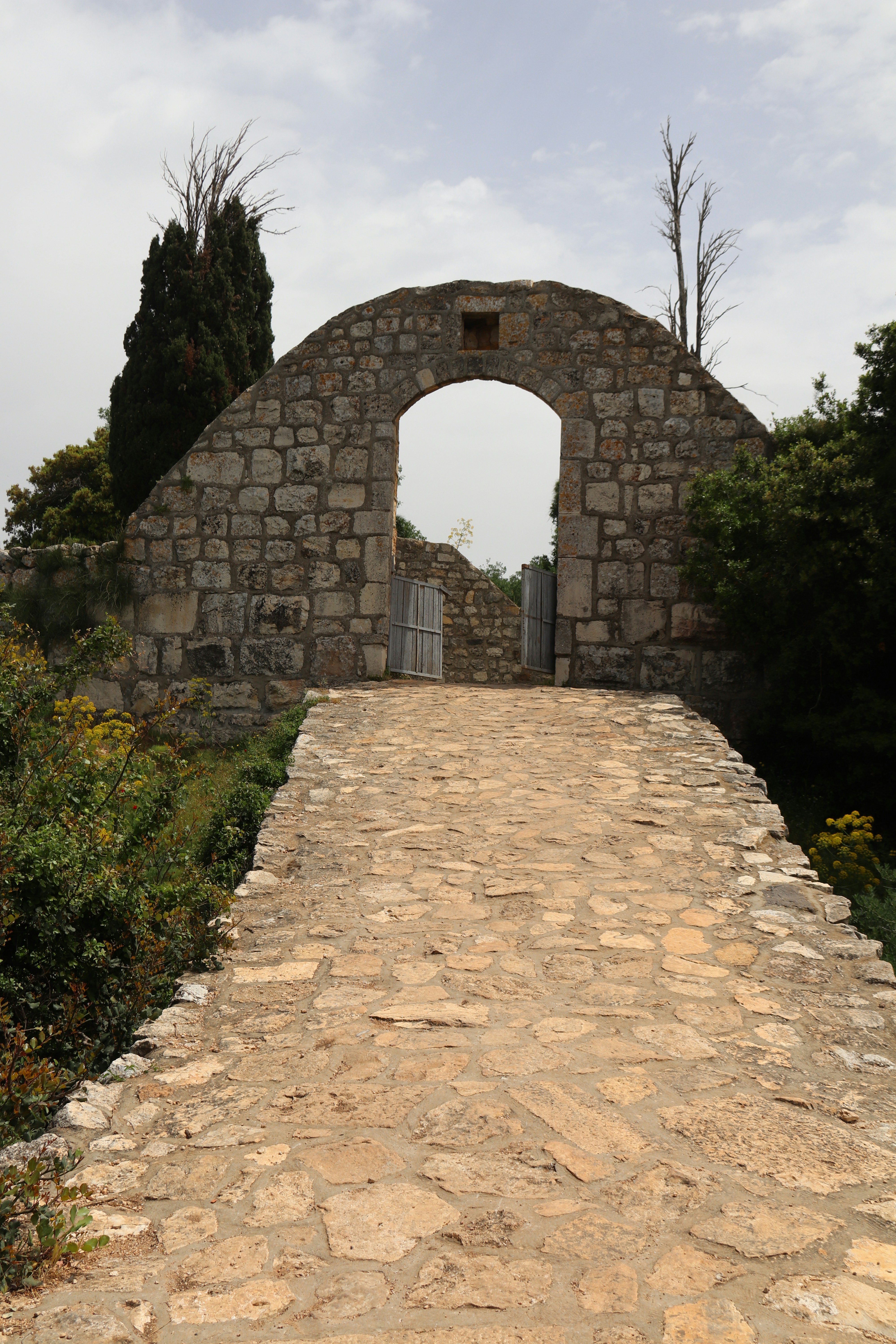 a stone walkway leading to a stone arch