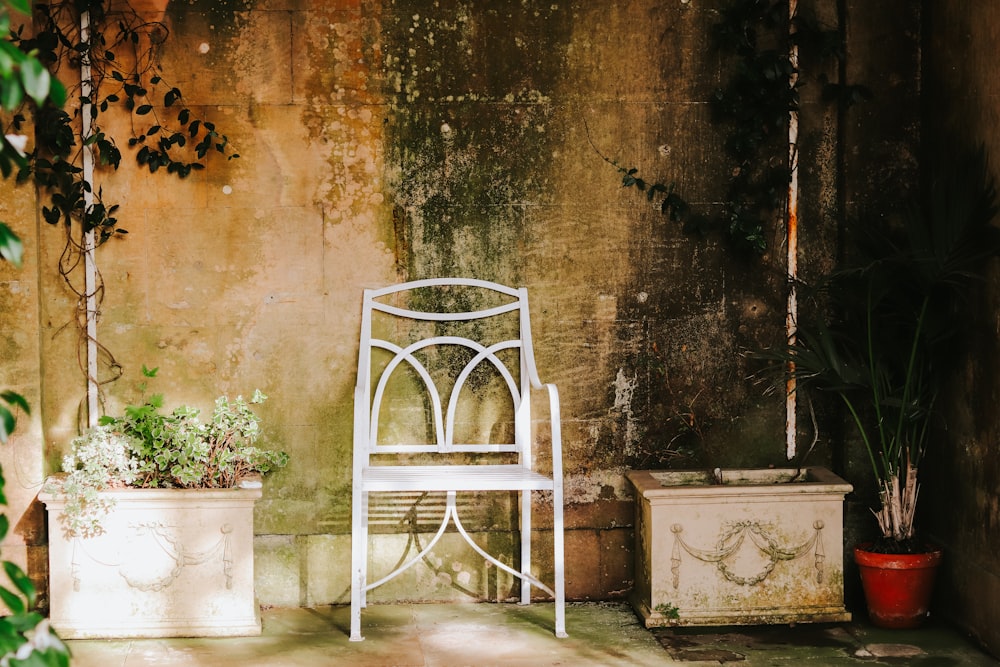 a white chair sitting next to a potted plant