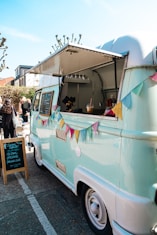 a blue and white food truck parked in a parking lot