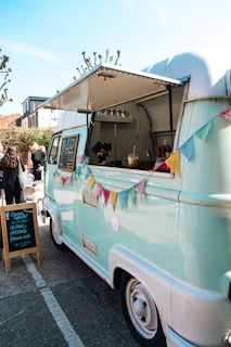 a blue and white food truck parked in a parking lot