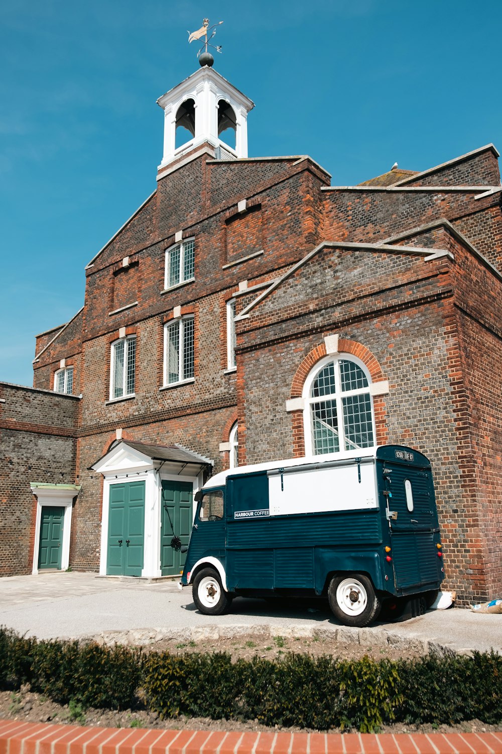 a blue and white van parked in front of a church