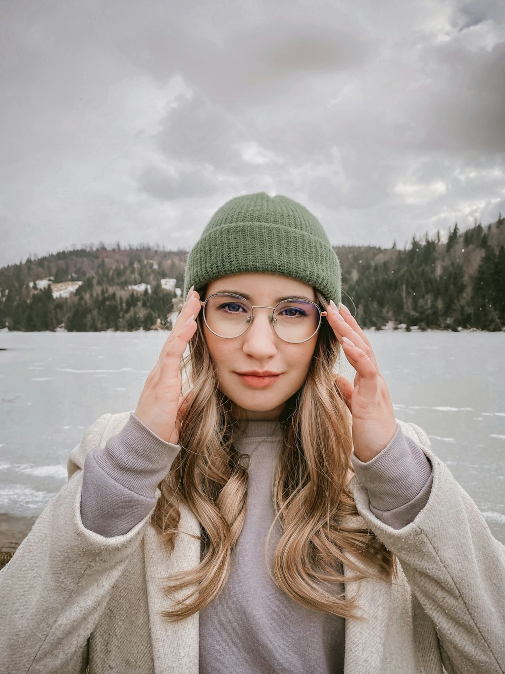 a woman wearing glasses and a green hat