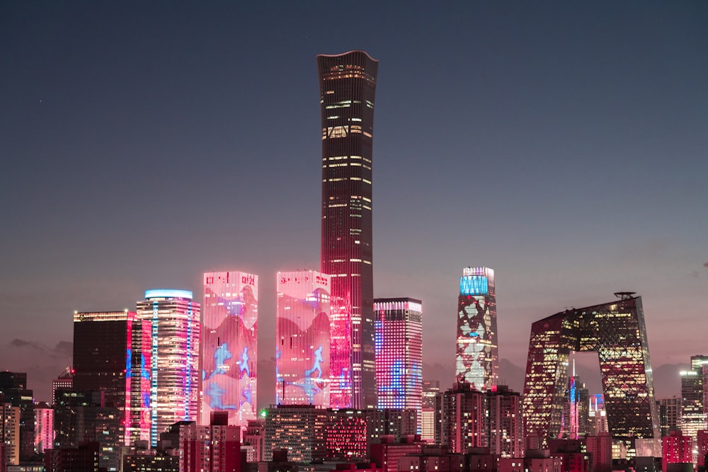 a city skyline with a lot of tall buildings lit up at night