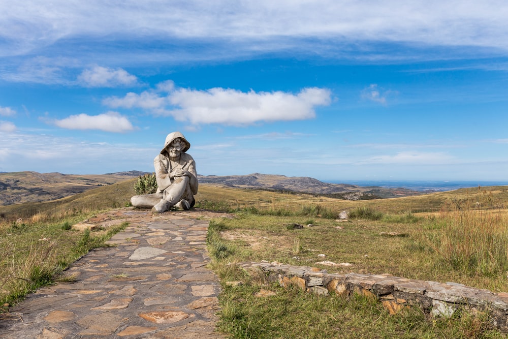 a statue of a person sitting on a stone path