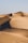 A vast desert landscape with rolling sand dunes. A person riding an off-road vehicle creates tracks across the dunes, capturing a sense of adventure and solitude.