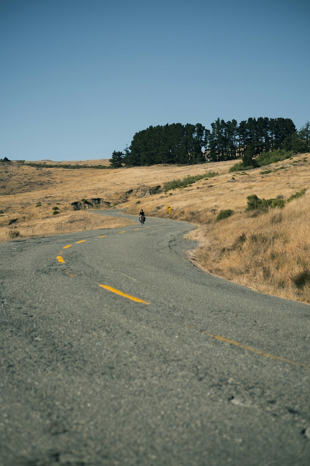 a man riding a motorcycle down a curvy road