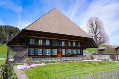 a wooden house with green shutters on a sunny day