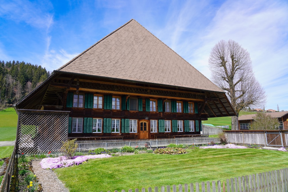 a wooden house with green shutters on a sunny day