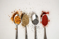 a row of spoons filled with different types of spices