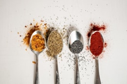a row of spoons filled with different types of spices
