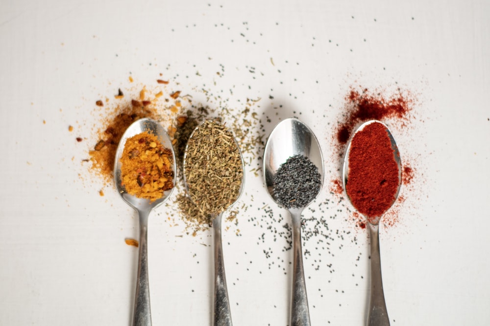 a row of spoons filled with different types of spices