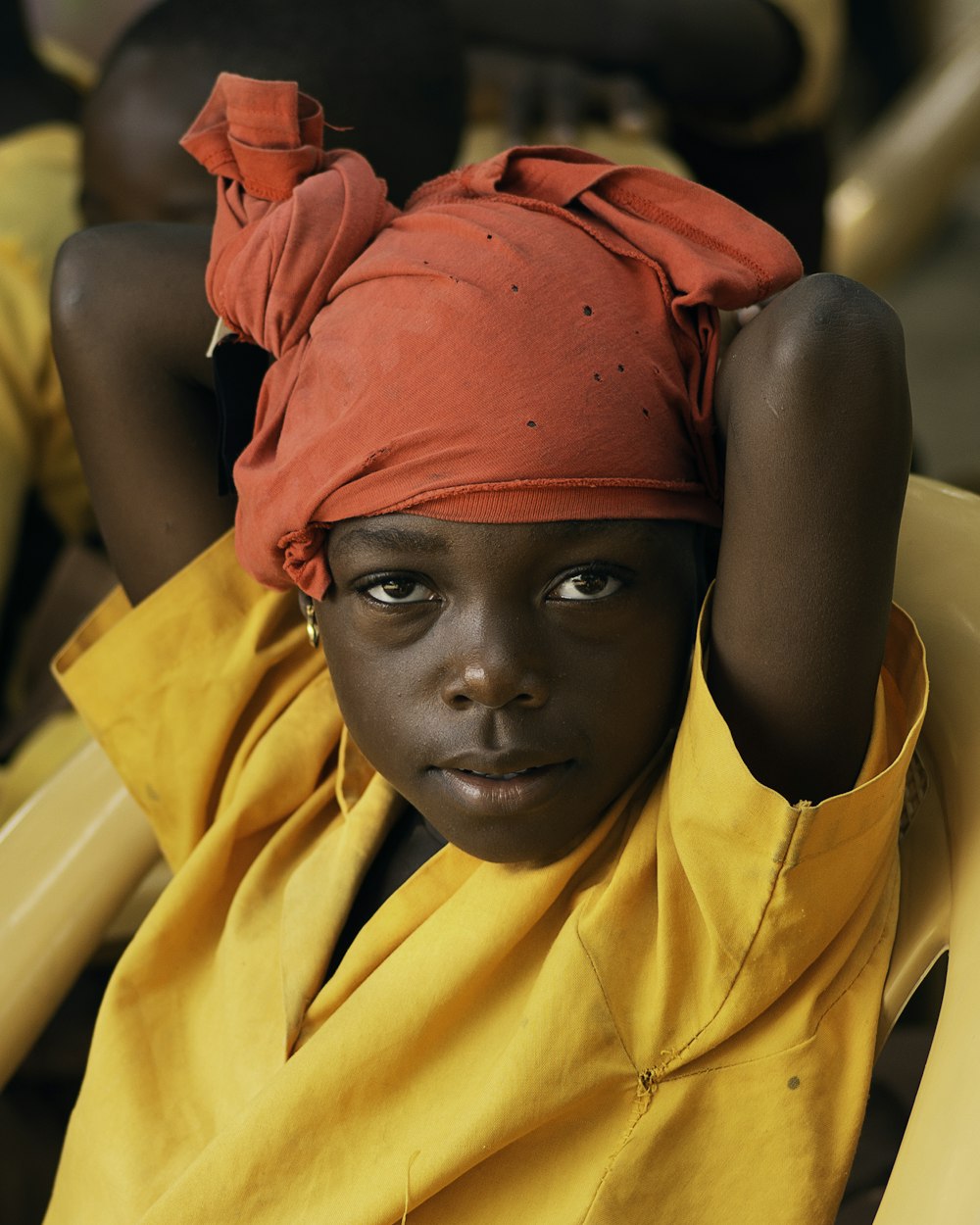 a young girl with a red turban on her head