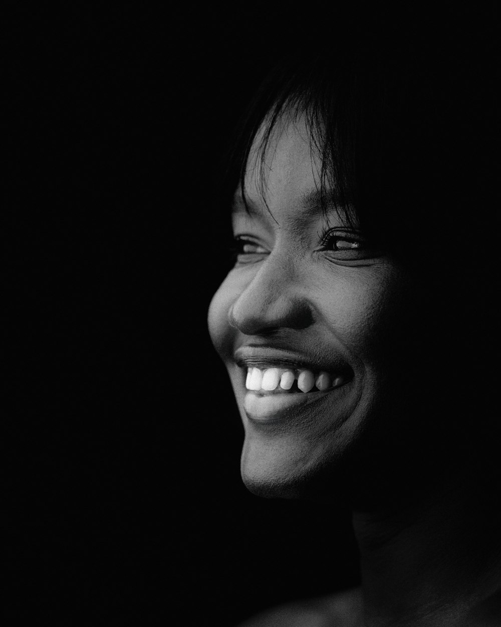 a black and white photo of a smiling woman