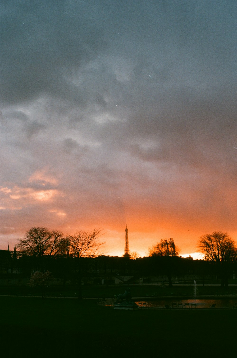 the sun is setting over a city with a tower in the distance