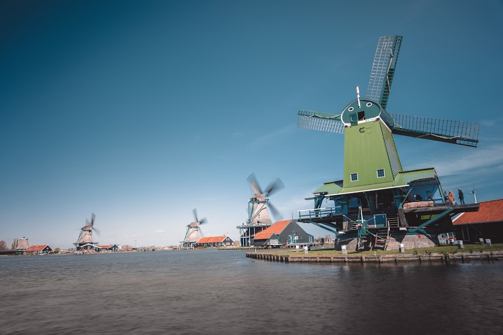 a group of windmills sitting next to a body of water