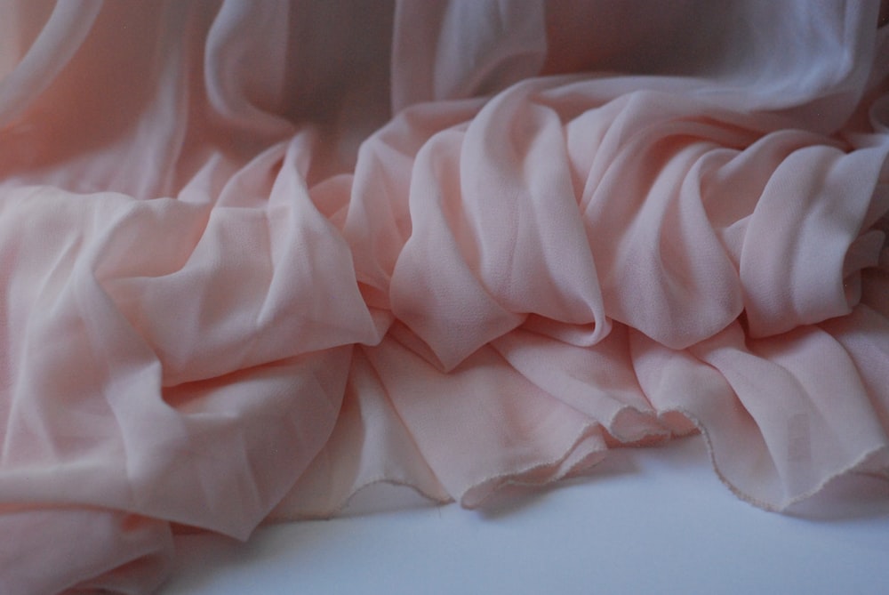 a close up of a pink fabric on a white surface