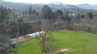 Sunlit open plot with clear boundary markers and a backdrop of Pune’s hills.