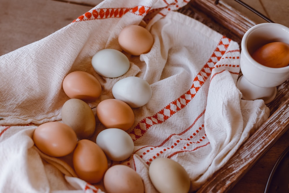 a basket filled with eggs next to a cup of coffee