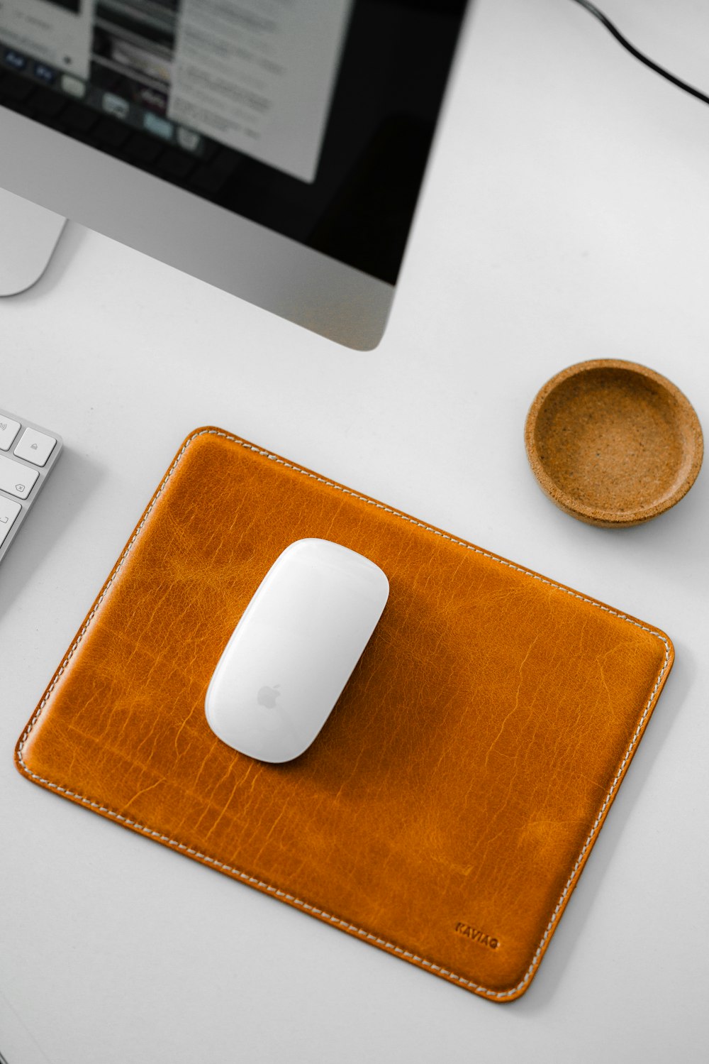 a computer mouse and a leather pad on a desk