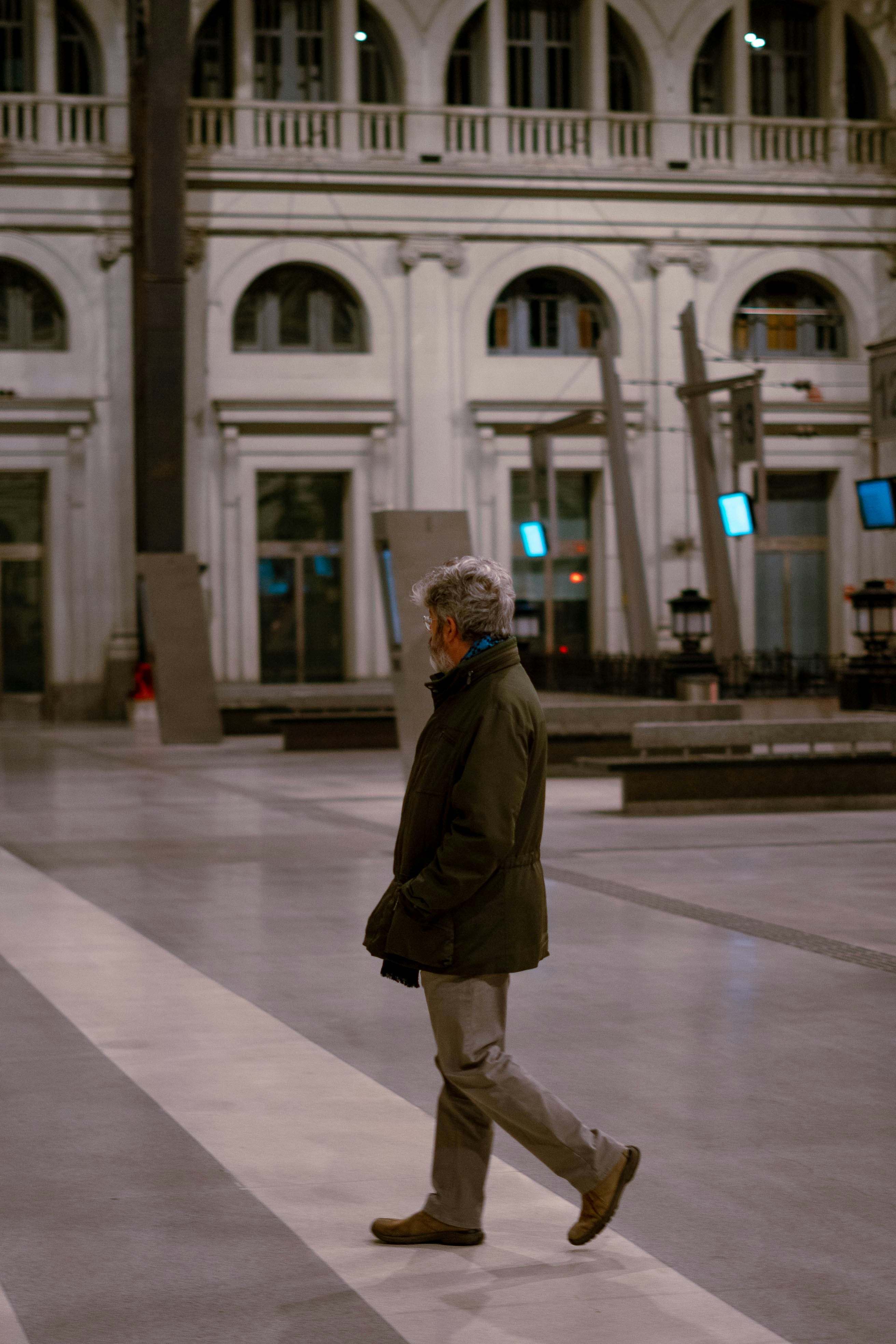 a man walking across a cross walk in front of a building