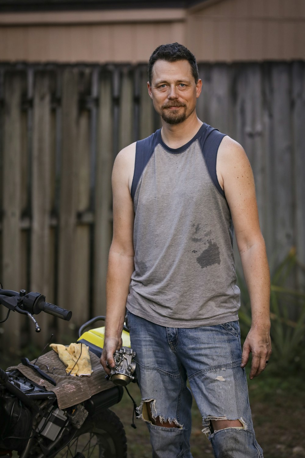 a man with a beard and mustache holding a bicycle