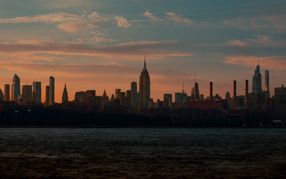 a city skyline with a body of water in the foreground