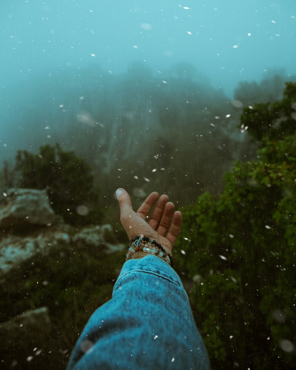 a person's hand in the rain