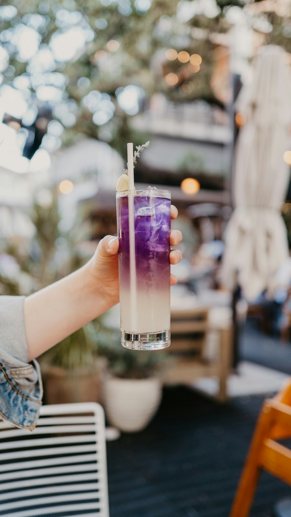 a hand holding a glass with a drink in it