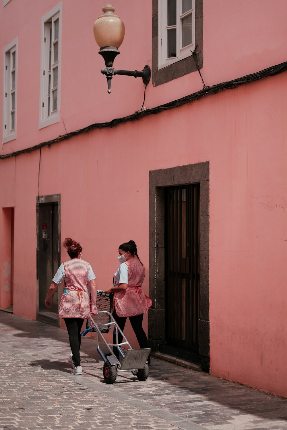 Una coppia di donne che camminano lungo un marciapiede con un passeggino