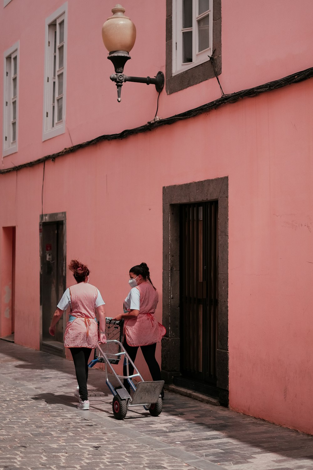 a couple of women walking down a sidewalk with a stroller