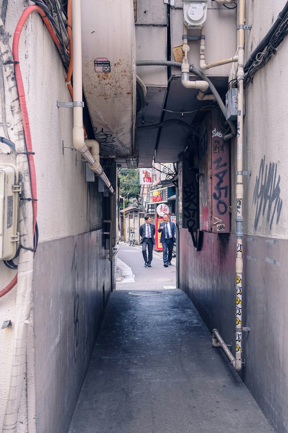 people walking down a narrow alley